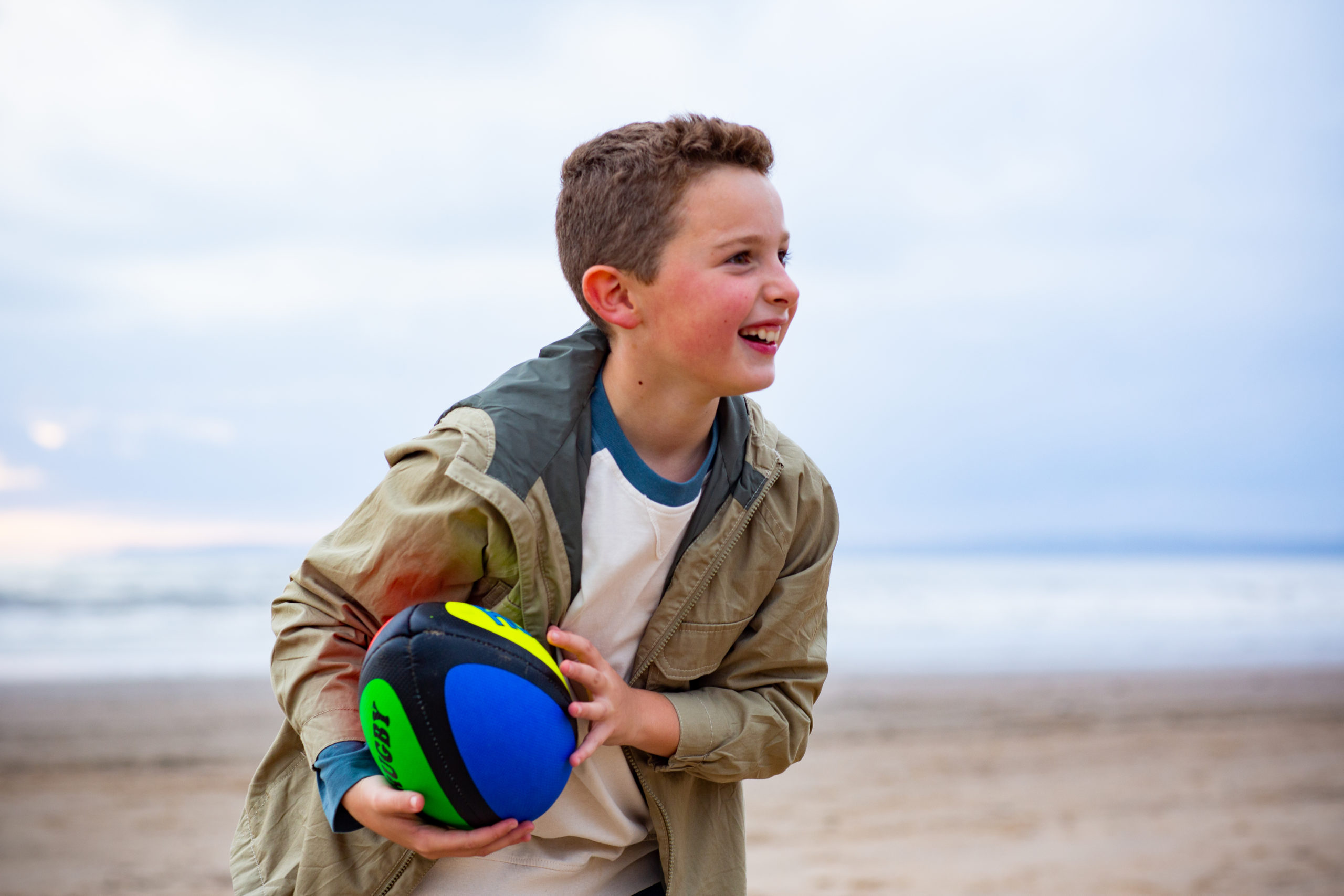 young boy smiling playing with ball
