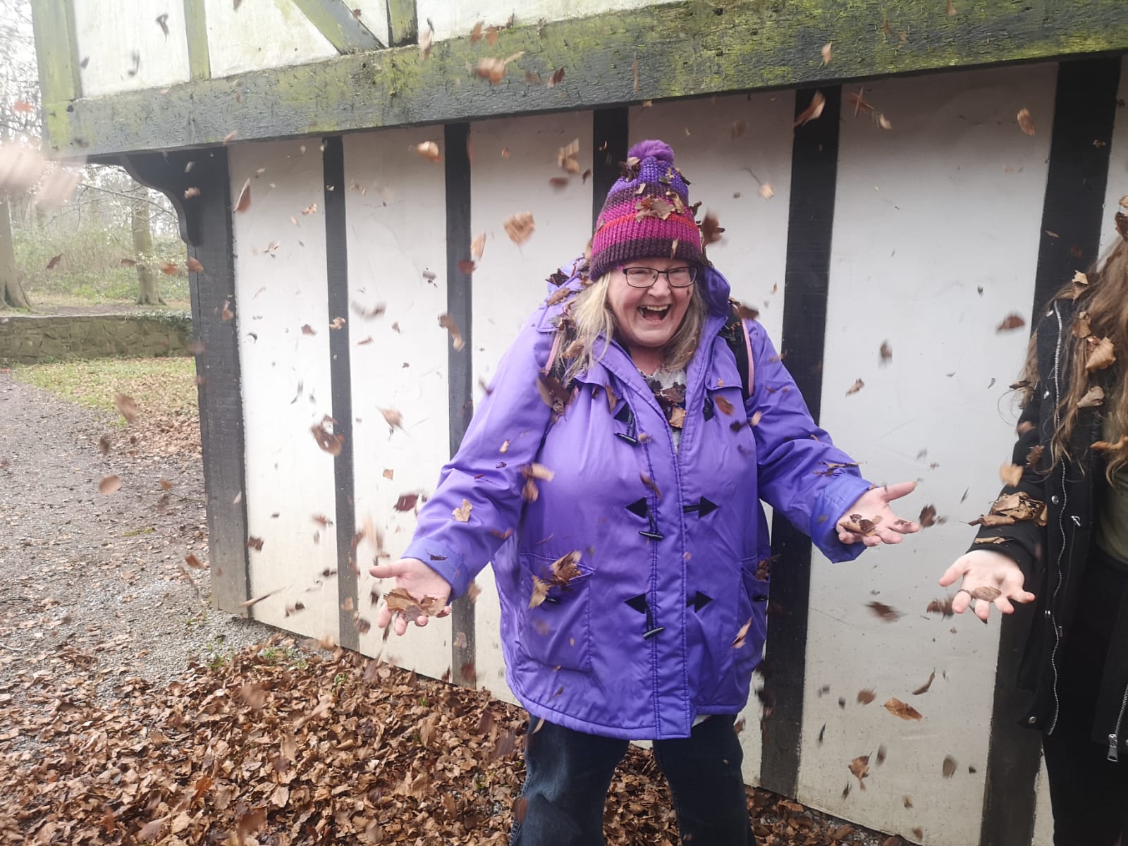 Foster Carer laughing with leaves falling down on her